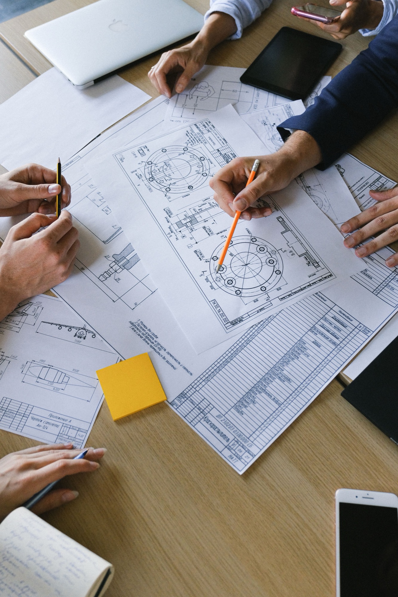 Hands reviewing measured drawings on a table