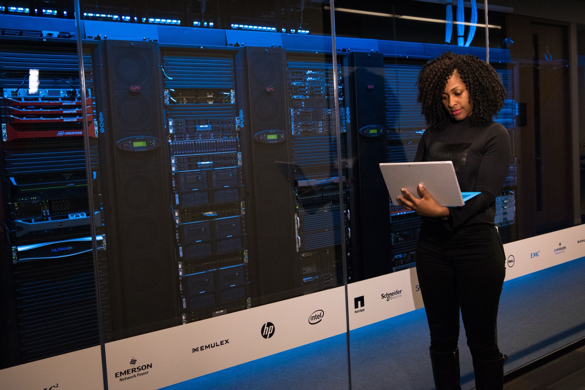 Engineer with a laptop beside live server cabinets